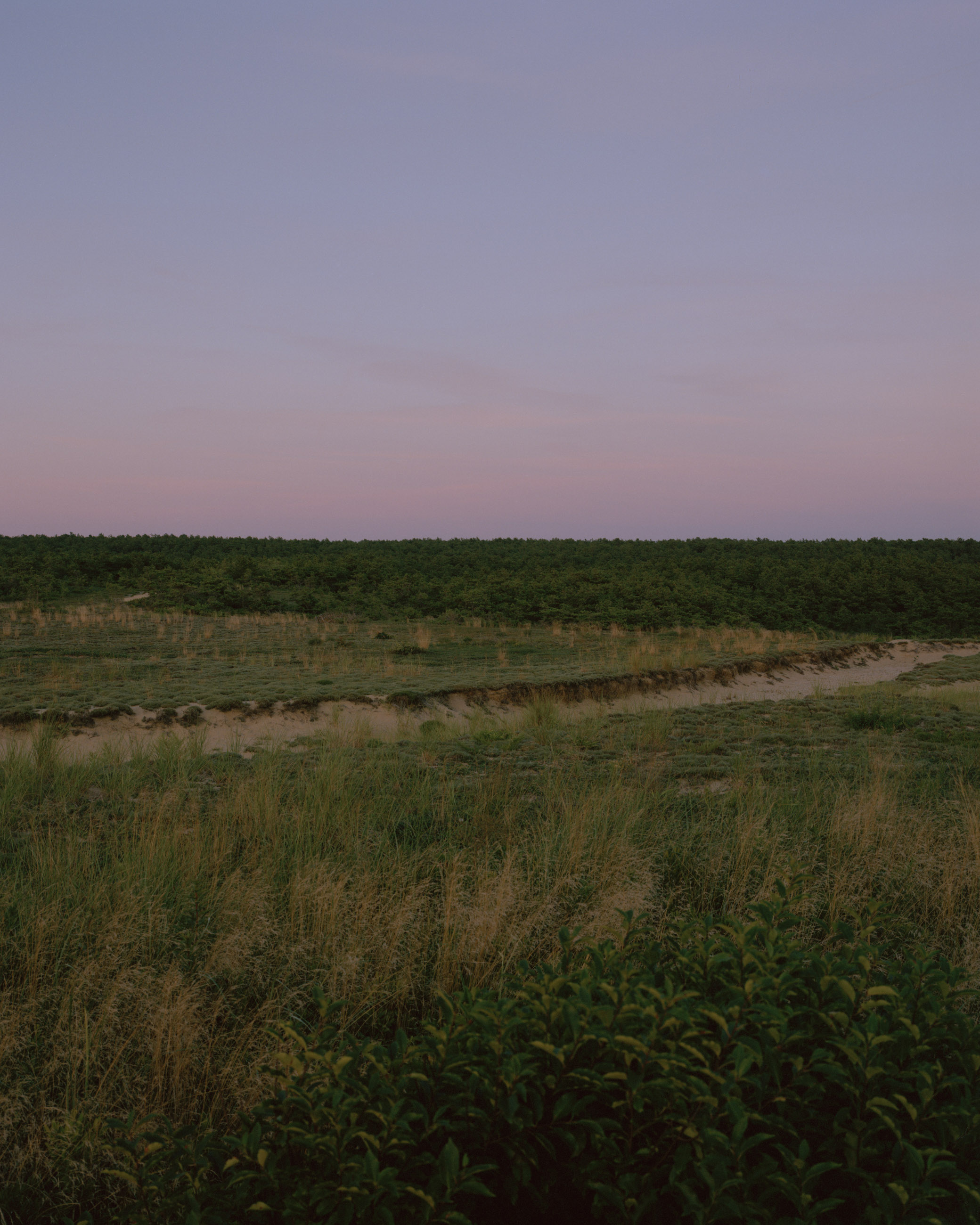 This eight-panel panoramic landscape photograph shows the rising moon on the left and the setting sun on the right from a vantage point overlooking Cape Cod Bay.