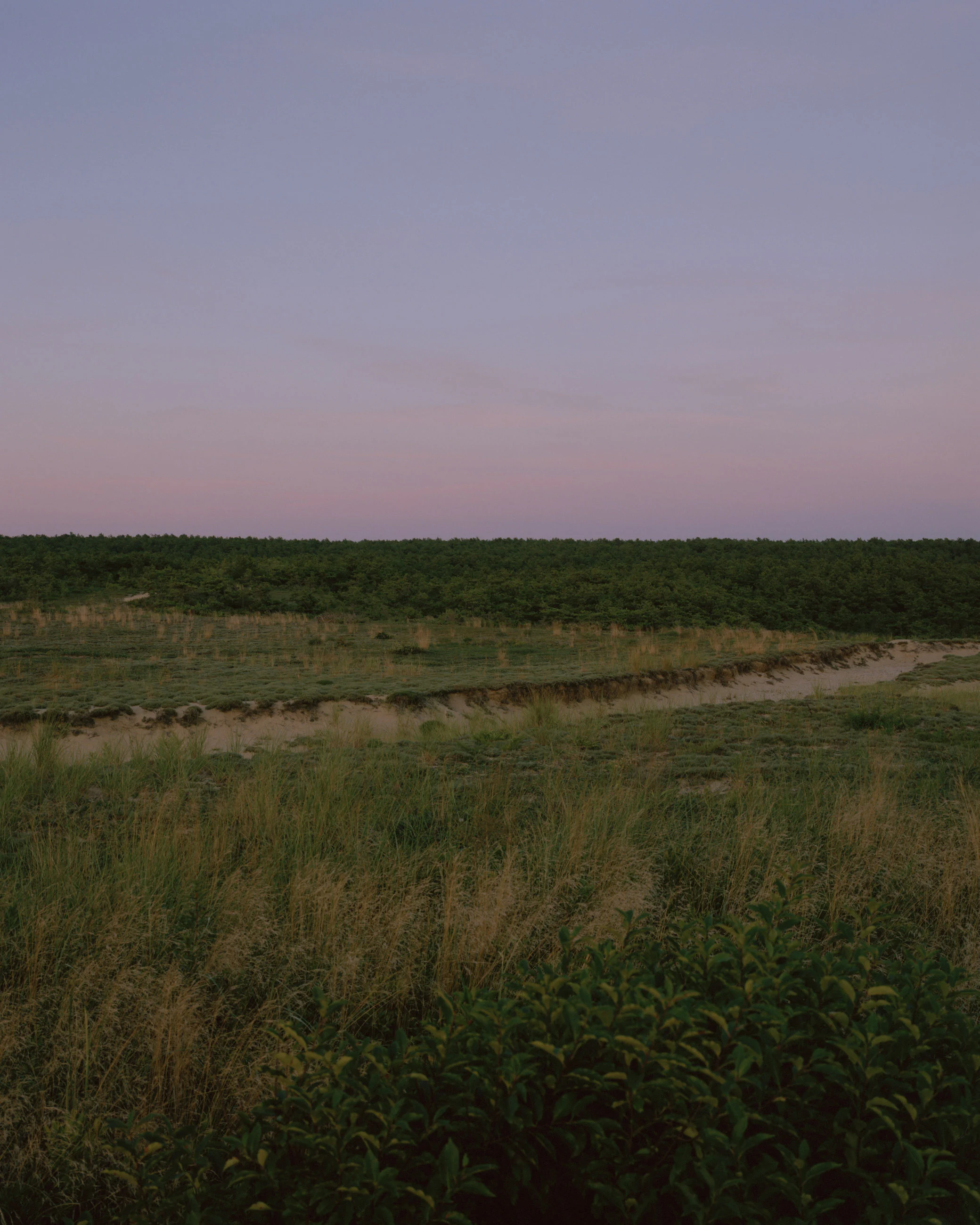 This eight-panel panoramic landscape photograph shows the rising moon on the left and the setting sun on the right from a vantage point overlooking Cape Cod Bay.