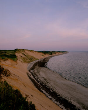 This eight-panel panoramic landscape photograph shows the rising moon on the left and the setting sun on the right from a vantage point overlooking Cape Cod Bay.