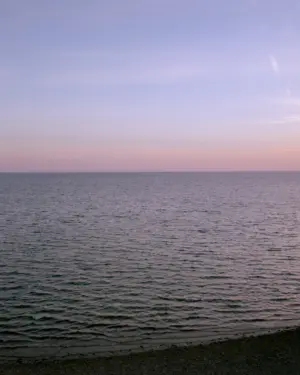 This eight-panel panoramic landscape photograph shows the rising moon on the left and the setting sun on the right from a vantage point overlooking Cape Cod Bay.