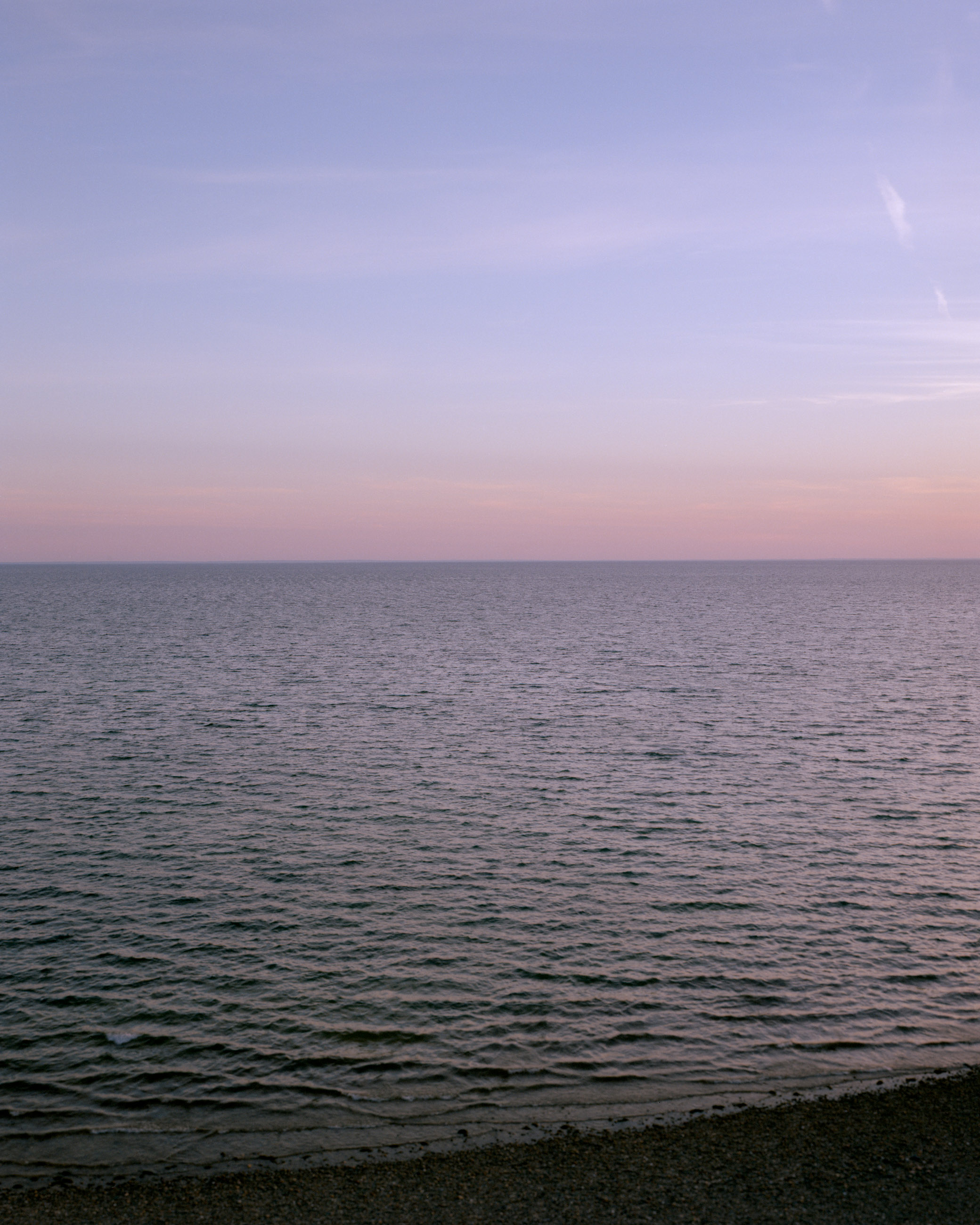 This eight-panel panoramic landscape photograph shows the rising moon on the left and the setting sun on the right from a vantage point overlooking Cape Cod Bay.