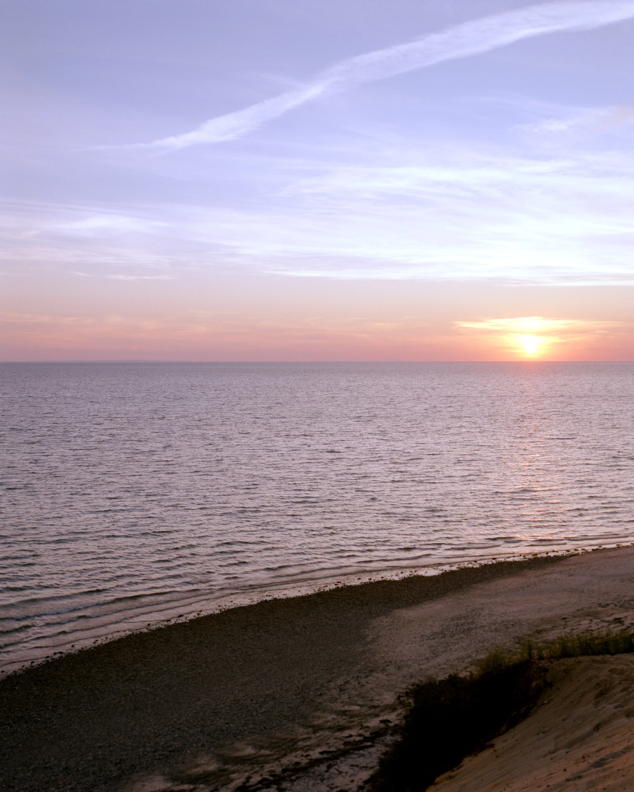 This eight-panel panoramic landscape photograph shows the rising moon on the left and the setting sun on the right from a vantage point overlooking Cape Cod Bay.