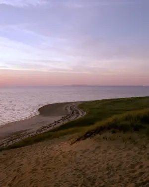This eight-panel panoramic landscape photograph shows the rising moon on the left and the setting sun on the right from a vantage point overlooking Cape Cod Bay.