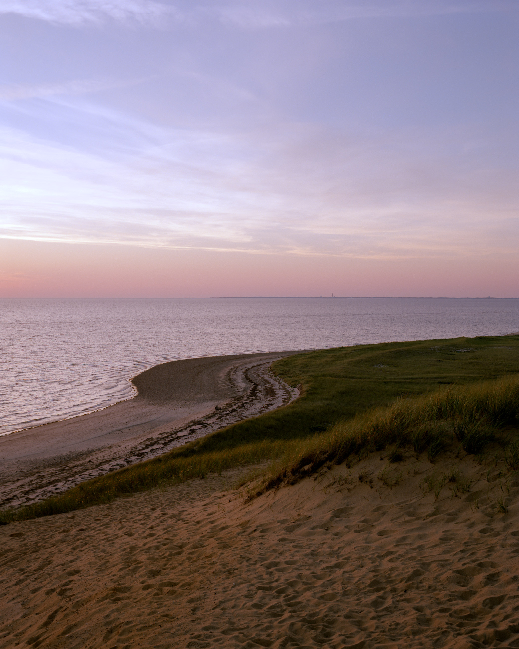 This eight-panel panoramic landscape photograph shows the rising moon on the left and the setting sun on the right from a vantage point overlooking Cape Cod Bay.