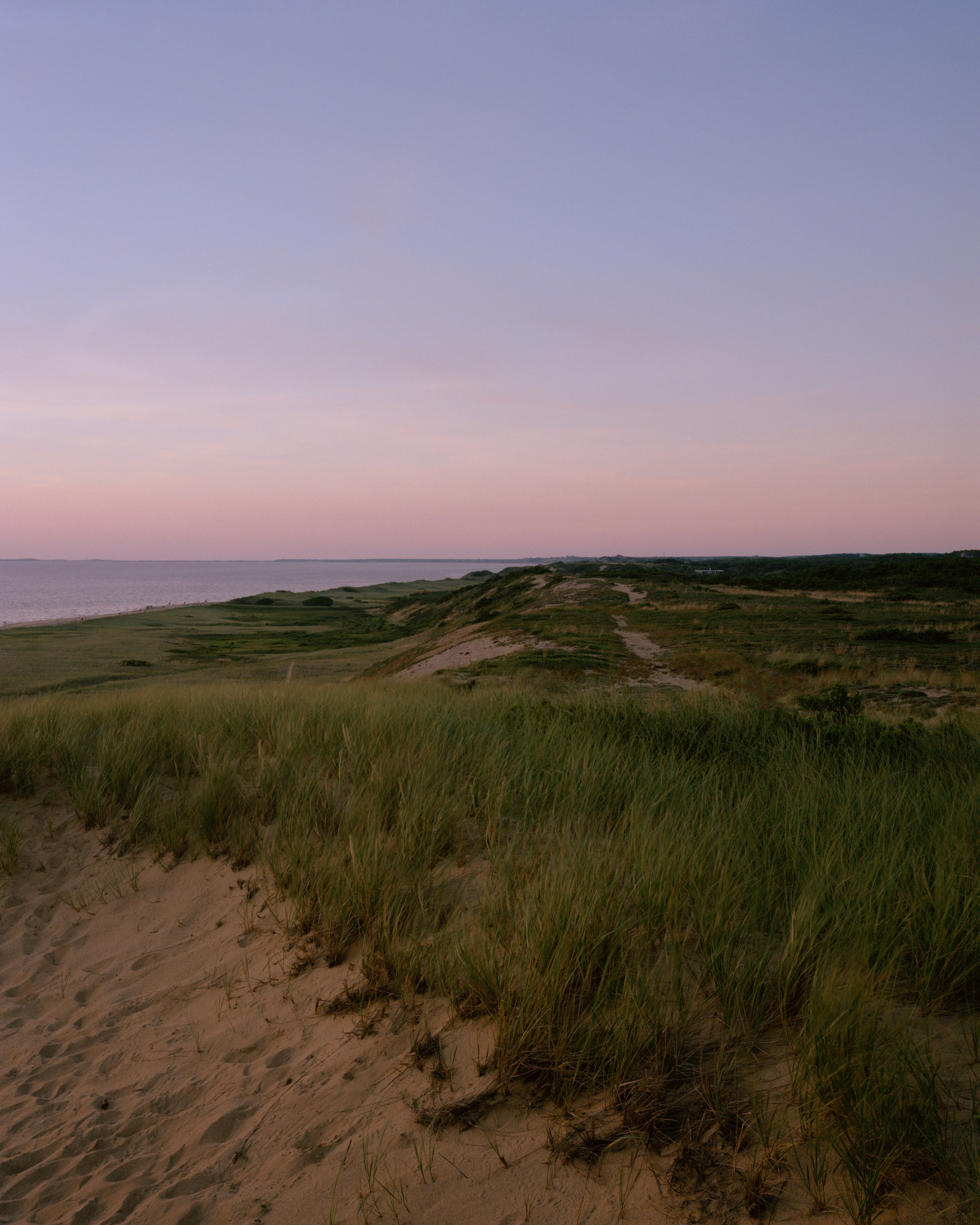 This eight-panel panoramic landscape photograph shows the rising moon on the left and the setting sun on the right from a vantage point overlooking Cape Cod Bay.